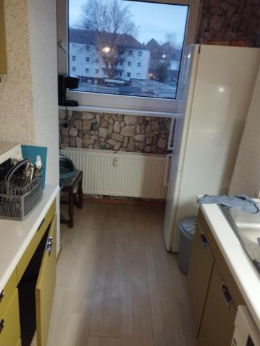 a kitchen with a refrigerator and a window at worker-flat in Gelsenkirchen