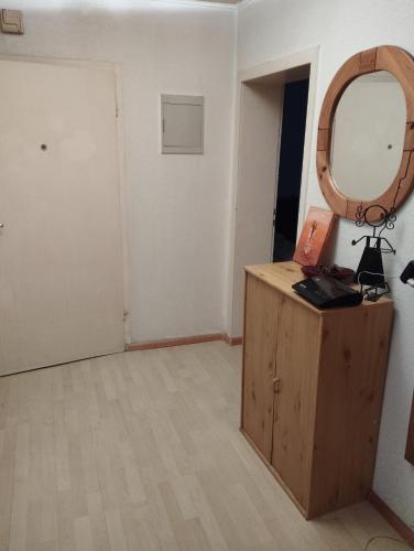 a room with a mirror and a wooden dresser at worker-flat in Gelsenkirchen