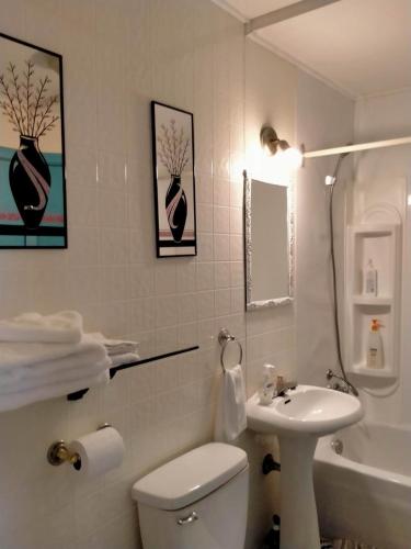 y baño con aseo blanco y lavamanos. en apartment avec parking privé en Quebec