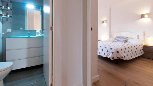 - Baño con dormitorio con cama y lavamanos en SEASIDE HOUSES, en Alcudia