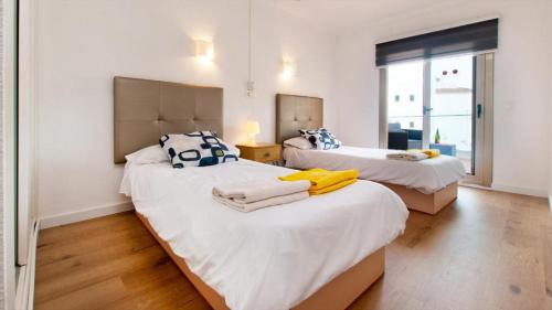 ein Schlafzimmer mit zwei Betten und einem Fenster in der Unterkunft SEASIDE HOUSES in Alcúdia
