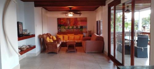 een woonkamer met een bank en een tafel en stoelen bij Villa #4 - Isla Contadora in Contadora