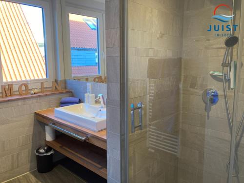 a bathroom with a sink and a shower at Haus Achterhus 215 - Wohnung 11 "Sandkörnchen" in Juist