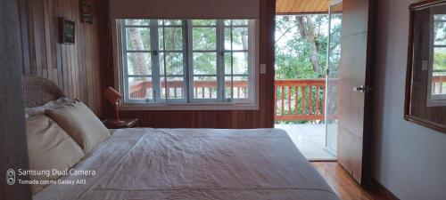 een slaapkamer met een bed en een groot raam bij Villa #4 - Isla Contadora in Contadora