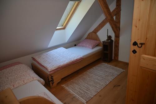 um quarto no sótão com 2 camas e uma janela em SLOVENIAN HOUSE GOSTECE-Vintage Apartma em Mozirje