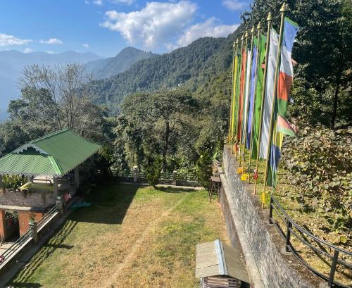 a row of flags on a wall with mountains in the background at Martam Farmhouse in Pelling