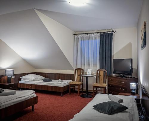 a hotel room with two beds and a tv at Czarna Owca in Istebna