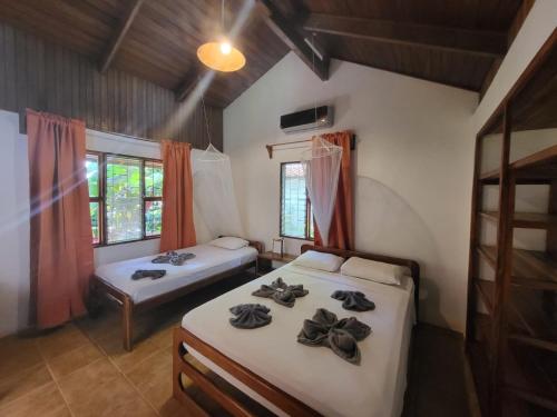 a bedroom with two beds and a window at Escape Caribeño in Puerto Viejo