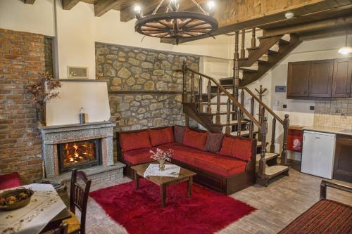 a living room with a red couch and a fireplace at T'Asprolithia in Kalyvia Fylaktis