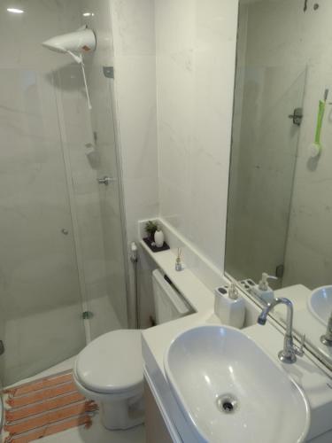 y baño con lavabo, aseo y espejo. en Boa viagem vista mar 3qts, en Recife