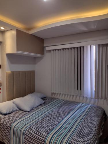 1 dormitorio con cama y ventana en Boa viagem vista mar 3qts, en Recife