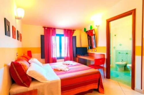 a colorful bedroom with a bed and a bathroom at Villa Sunset B&B/Apartments in Fontane Bianche