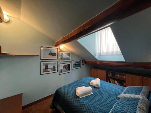 Un dormitorio con una cama azul con toallas. en Mansarda Sul Porticciolo 1b/1b 50mq with seaview, en Génova