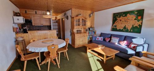 een woonkamer met een blauwe bank en een tafel bij Edelweiss 6 in Champoussin