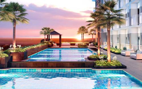 une piscine bordée de palmiers et un bâtiment dans l'établissement Luxury Sunset Views and Prime Location near CCP MOA with WIFI Parking, à Manille