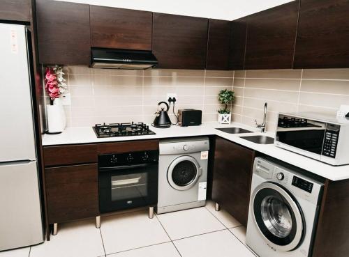 a kitchen with a washer and dryer in it at Secure and comfortable , Fully equipped Unit in Lombardy East