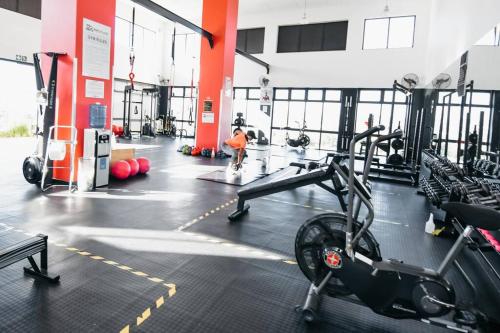 a gym with cardio equipment and a man in the background at Secure and comfortable , Fully equipped Unit in Lombardy East