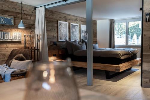ein Schlafzimmer mit einem Bett in einem Zimmer mit Holzwänden in der Unterkunft Loft am See in Arosa