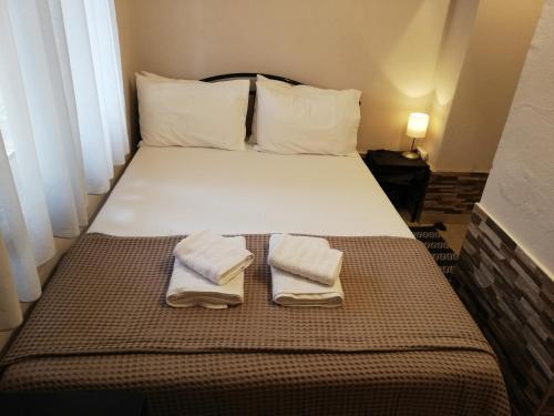 ein Schlafzimmer mit einem Bett mit zwei Handtüchern darauf in der Unterkunft Forest 22 in Kavala