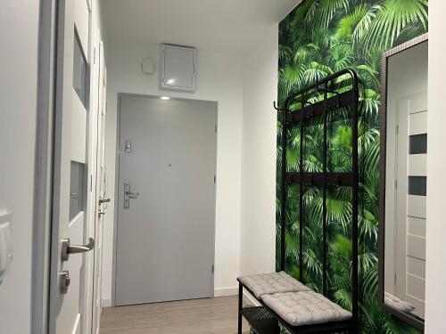 un couloir avec un mur vert et un banc dans l'établissement Apartament Nikodema, à Leszno