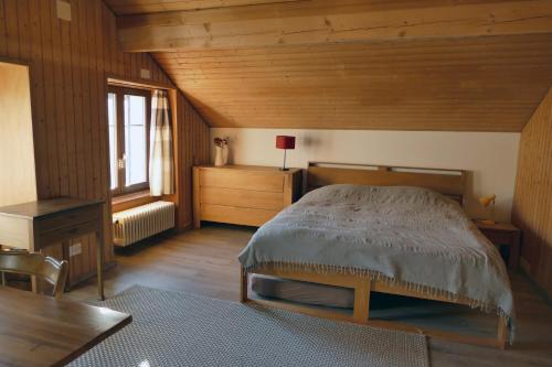 - une chambre avec un lit, une table et une fenêtre dans l'établissement Drosera appartement et studio de vacances, à La Chaux-du-Milieu