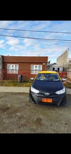 une voiture garée dans un parking en face d'une maison dans l'établissement Héctor cabañas, à Punta Arenas