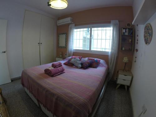 Un dormitorio con una cama con sábanas moradas y una ventana en AM Bas Confort - Bienes Reales en Córdoba