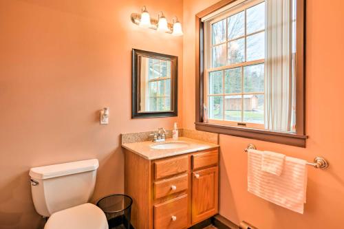 a bathroom with a toilet and a sink and a window at Cozy Wilcox Home on East Branch of Clarion River! in Wilcox