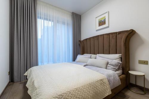 a bedroom with a large bed and a window at Amber Stone Apartment 1st floor in Palanga