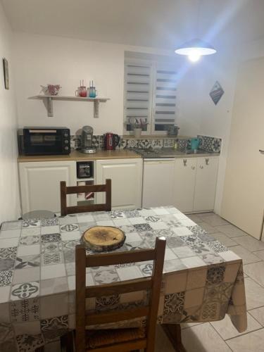 une cuisine avec une table et des chaises et une table et une cuisine dans l'établissement la maison bleue appart 1, à Remoncourt
