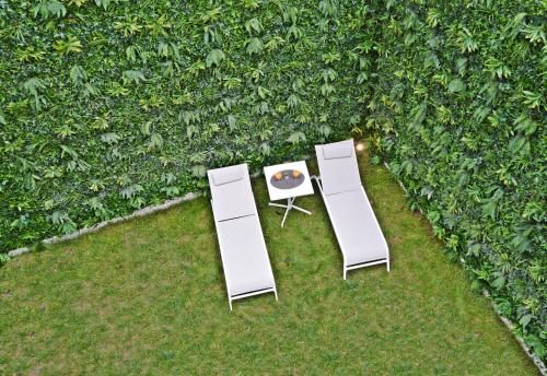 two white tables and chairs in front of a wall at Lisbon City Hollywood Hotel by City Hotels in Lisbon