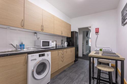 eine Küche mit einer Waschmaschine und einer Theke in der Unterkunft Home in Levenshulme, Manchester in Manchester