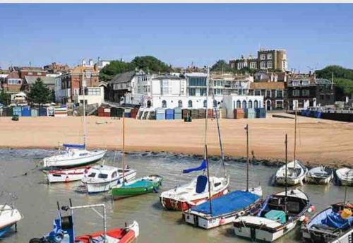a group of boats in the water near a beach at Rivendell Modern 2 Bedroom apartment in St Peters village sleeps 6 in Kent