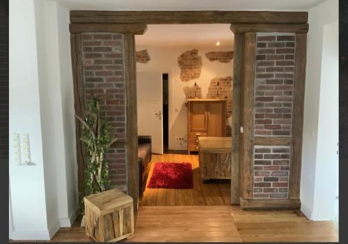 an open door into a room with a brick wall at Hildas Idyllische Ferienwohnung in Gödenstorf