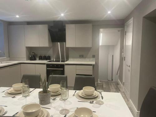 a kitchen with a table with plates and glasses on it at Rivendell Modern 2 Bedroom apartment in St Peters village sleeps 6 in Kent