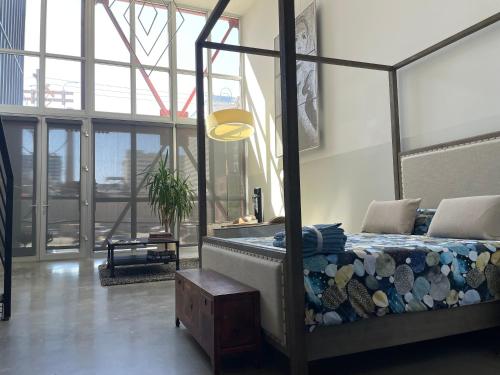 a bedroom with a canopy bed and a large window at Duplex Suite in Art Tower in Philadelphia