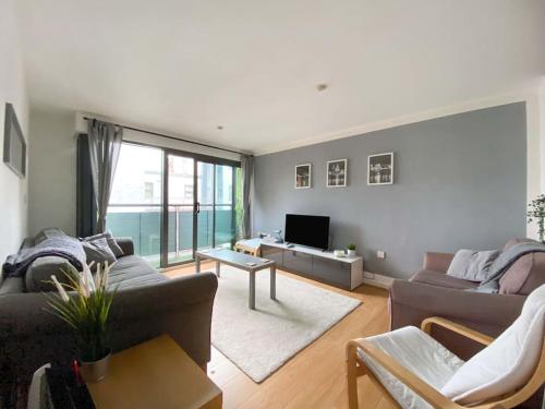 a living room with a couch and a tv at Liverpool One Beautifully Presented 2 Bedroom Apartment in Liverpool