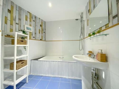a white bathroom with a tub and a sink at Beautifully Presented 2 Bedroom Apartment in Liverpool