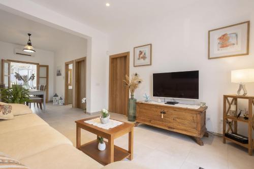 a living room with a couch and a flat screen tv at Can Toni in Can Picafort