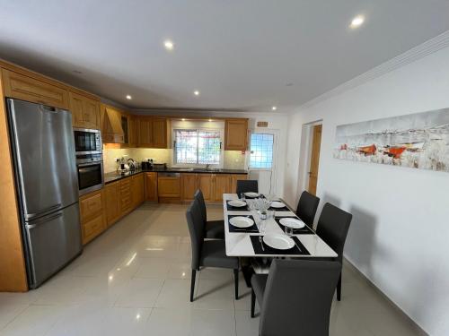a kitchen with a table with chairs and a refrigerator at Dream Beachfront Bungalow in Limassol