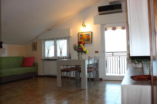 una cucina e un soggiorno con tavolo e sedie di Bellavista garden and flowers a Varenna