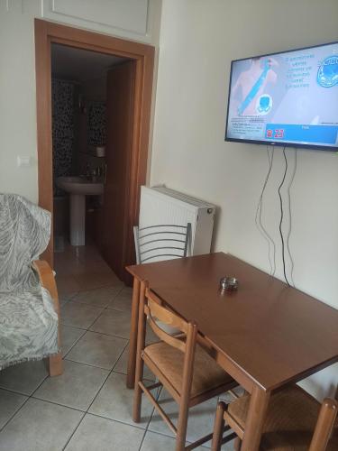 sala de estar con mesa y TV en la pared en Averof, en Preveza