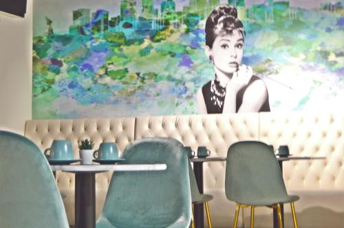 a painting of a woman on a wall with chairs at Lisbon City Hollywood Hotel by City Hotels in Lisbon