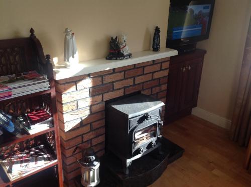 a brick fireplace with a stove in a room at Seber House in Kilbeggan