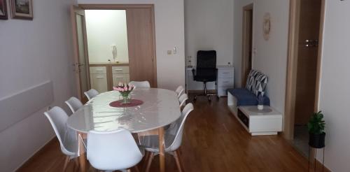 a dining room with a white table and white chairs at Marys Home Apartment Međugorje in Međugorje