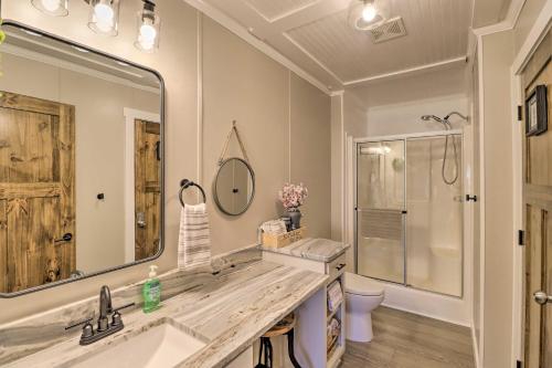 a bathroom with a sink and a large mirror at Lakefront Greers Ferry Cabin with Covered Boat Slip! in Fairfield Bay