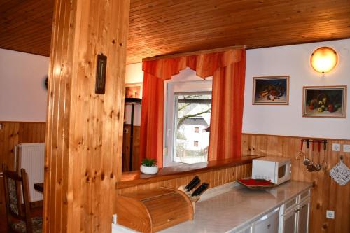 a kitchen with a counter with a window and a microwave at Apartments Lenc in Bovec