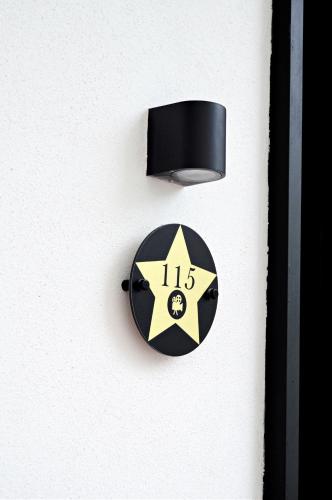 a black and yellow clock on a white wall at Lisbon City Hollywood Hotel by City Hotels in Lisbon