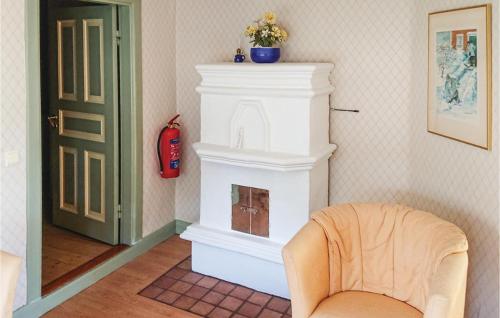 a living room with a fireplace and a chair at 3 Bedroom Gorgeous Home In Broakulla in Broakulla