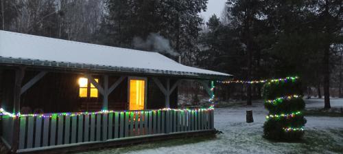 une maison recouverte de lumières de Noël dans la neige dans l'établissement U Stefanów, à Królowy Most
